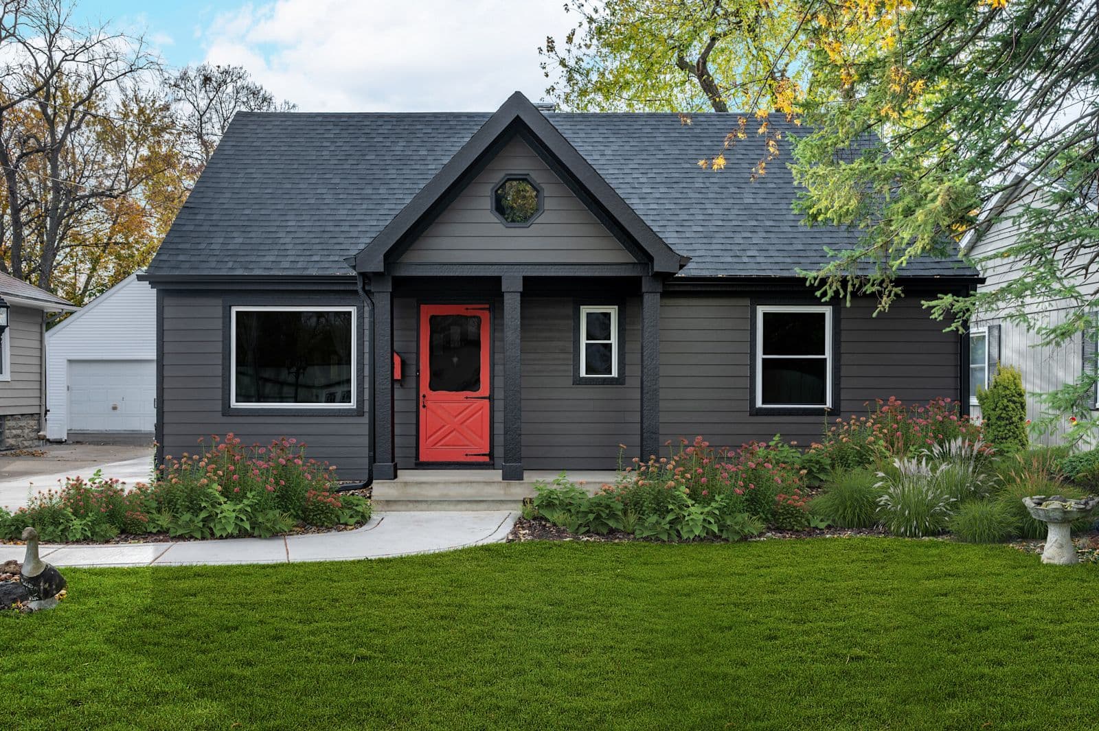 James Hardie charcoal HardiePlank lap home with white trim and a red door